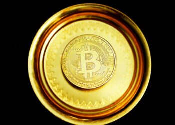 gold round coin on black surface